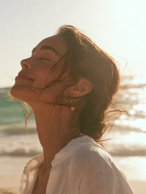 Imagen ilustrativa de lipopapada: modelo en la playa al atardecer